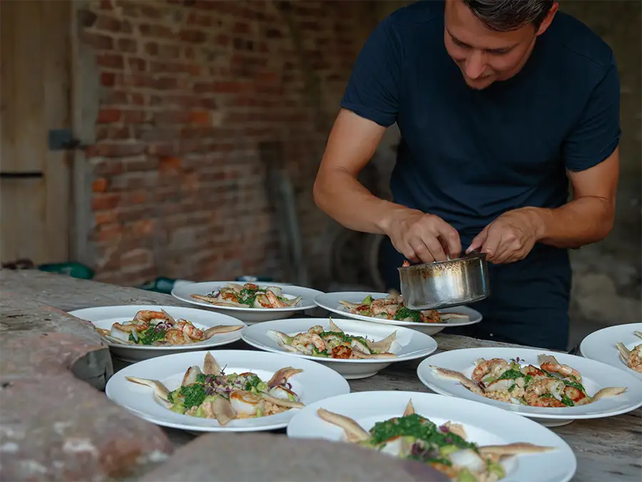 Kok van Jeff’s Catering maakt meerdere borden met gerechten op